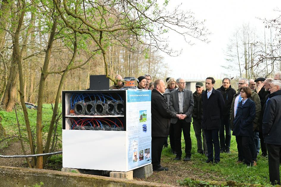 Mobiler Generator-Teststand neben dem Mühlkanal. DEGREEN-Projektleiter Dr. Bernhard Brunner erläutert Besuchern die Funktionsweise der Foliengeneratoren.