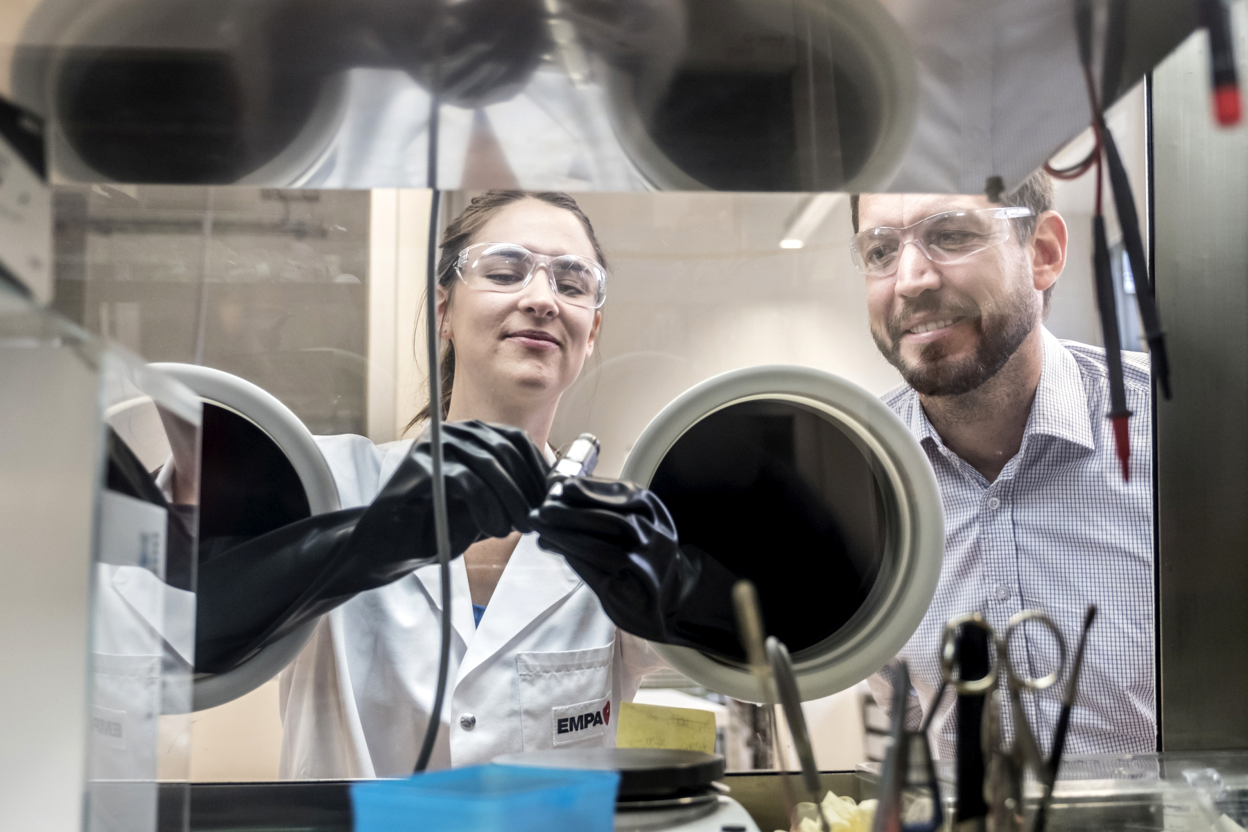 Marie Claude Bay and Corsin Battaglia work in a glove box on the solid state batteries of the future. 